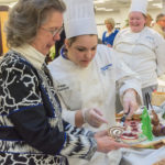 Paige E. Pearson, of Williamsburg, serves a slice of buche de Noel to Joann Ertel, whose father, Kenneth E. Carl, was director of Williamsport Technical Institute and president of Williamsport Area Community College, both forerunners of Penn College.