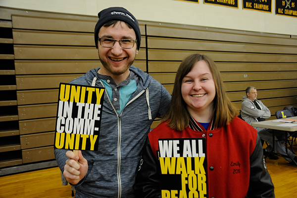 Graphic design students Joseph N. Colyer, of Selinsgrove, and Emily R. Kahler, of Pitman, carry college-prepared placards ...