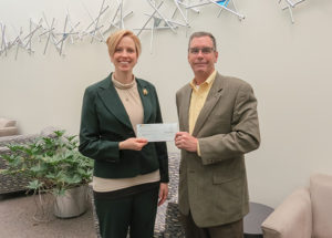 Brian Fuhrman, public sector solutions major account manager for Waste Management, presents a check to Elizabeth A. Biddle, director of corporate relations for Pennsylvania College of Technology. The $8,500 gift will support the college’s Penn College NOW dual-enrollment program and SMART Girls summer camp. Both are for high school students.