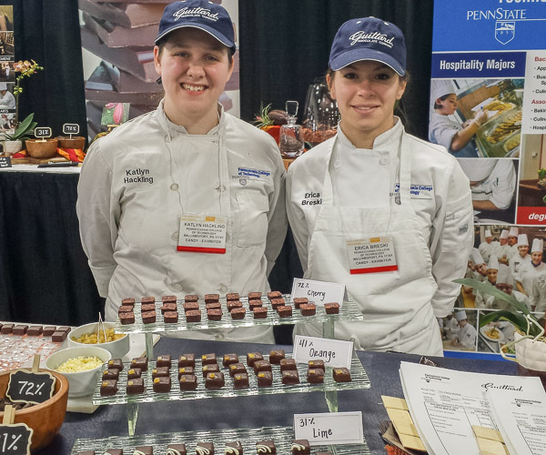 Students Katlyn J. Hackling and Erica Breski show off bonbons they prepared for Philadelphia National Candy Show attendees.