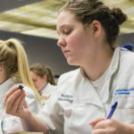 Katlyn J. Hackling, who is pursuing degrees in both culinary arts and systems and baking and pastry arts, initiates the first step in chocolate tasting by evaluating its color tone.