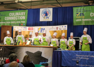 Students in Penn College’s hospitality majors join their instructor, Chef Michael J. Ditchfield, on the Culinary Connection stage at the Pennsylvania Farm Show. Over three days, 11 Penn College students did behind-the-scenes prep work and served as on-stage assistants for 19 demonstrations by noted Pennsylvania chefs.