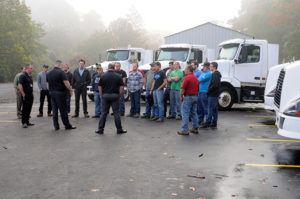 Amid six trucks that were donated in the past year, FedEx Freight representatives and Penn College faculty gather outside the Schneebeli Earth Science Center to share career advice with diesel technology students.