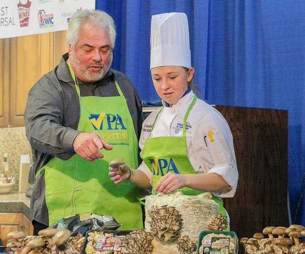 Danielle M. McGuire helps David Santucci, regional sales manager for Country Fresh Mushrooms, to show varieties of mushrooms.