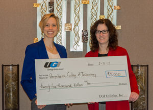 Elizabeth A. Biddle, left, director of corporate relations for Penn College, accepts a gift of $25,000 from Ann Blaskiewicz, community relations manager north for UGI Utilities. The gift supports the college Penn College NOW and SMART Girls programs, both of which promote technology education for high school students.