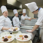 Ditchfield (background), instructor of hospitality management/culinary arts, and students from the School of Business & Hospitality