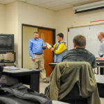 With instructor Andrew R. Wolfe watching from right, PPL's Chuck Wood (left) demonstrates personal protective equipment with the help of electrical technology major John J. Aleksiejczyk IV, of Hatboro.
