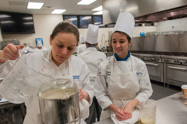 Chef Elaine Gardner works alongside first-semester culinary arts technology student Katrina L. Maldonado, of Douglassville, on the base for a signature hummus offering.