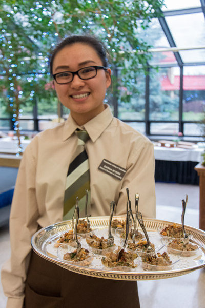 Pre-nursing student Sarah E. Myers, of Williamsport, serves a tray of hummus during a pre-dinner reception.