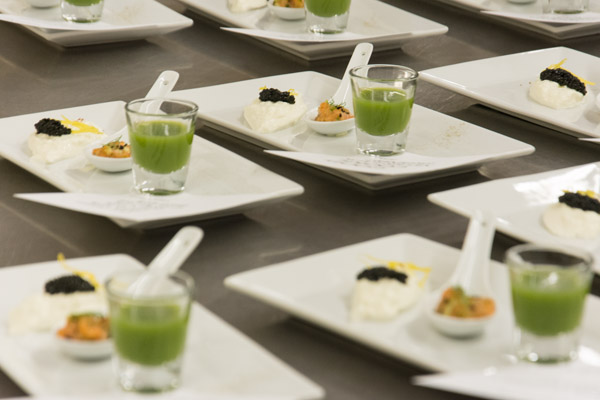 The appetizer course awaits pickup by the evening’s “front-of-house” staff. The dish includes an Asian salmon tartare spoon, burrata cheese and caviar, and a green apple shooter.