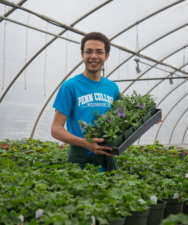 With a warm smile, colorful T-shirt and blooms on hand, Aaron A. Sledge Jr., a freshman in landscape/horticulture technology: plant production emphasis from Pittsburgh, is ready to share his love of plants with visitors. 