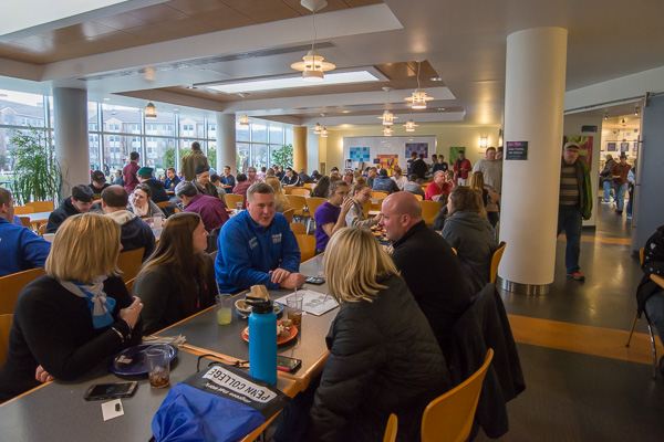 Elliott Strickland (center, in blue), chief student affairs officer, visits with a family in Rose Street Commons' bustling dining hall, joined by Carolyn R. Strickland (left), vice president for enrollment management and associate provost.