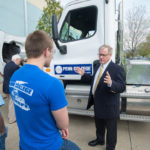 Wagner discusses his waste-management and trucking businesses with diesel technology students alongside a diesel truck outside College Avenue Labs.