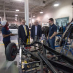 In the automotive restoration lab, the senators listen to insights shared by Vanessa Mathurin, of Philadelphia, and Sean M. Hunter, of Livingston, N.J. The students are automotive restoration technology graduates enrolled in applied management. 