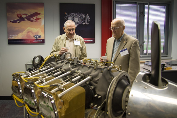 John Shafer (left), ’50, automotive mechanic, and Robert Fries, ’45, aviation mechanics, enjoy coffee and conversation over a Lycoming engine. 