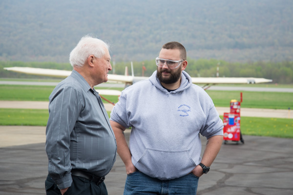 James Oberlin, powerplant mechanic and airframe mechanics alumnus, engages aviation technology student Jesse L. Pittenger in conversation on the tarmac. 