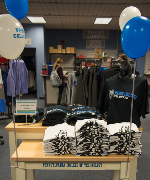 A festive table in The College Store offers the new logo on T-shirts. 