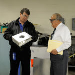 The visitor stops by the sheet-metal shop with faculty member Thomas D. Inman.