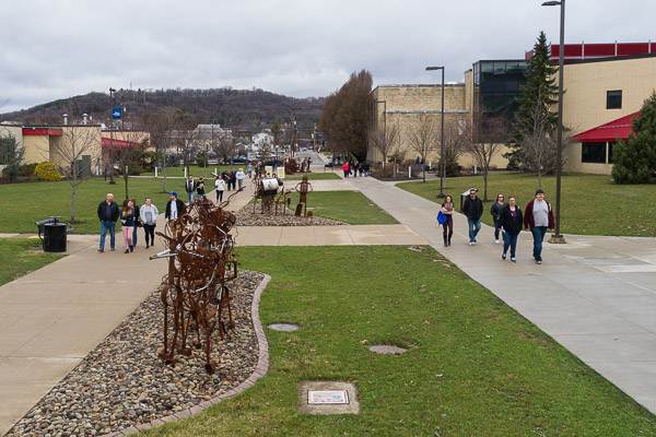 Pedestrians walk along both side of the campus mall, paralleling the 