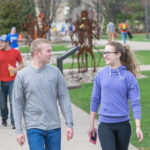 Students walk the campus mall in support of healthy relationships, racking up steps alongside the welded "Student Bodies" sculptures.