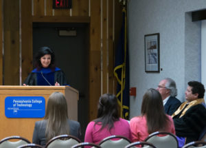 Faculty member Lisa M. Andrus addresses this year's membership class; adviser Joe Nededog is at right.