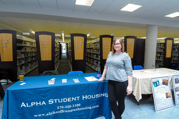 Alpha Student Housing's Laura Labs, representing one of the many reputable neighborhood landlords, staffs a table at the Off-Campus Housing Expo in the library.