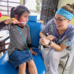 Nursing student Kelsey L. Maneval interacts with a child in the clinic's dental area.