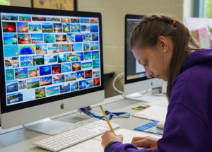 A camper pores through images for a make-believe coffee shop during last summer’s Graphic Design Summer Studio at Penn College.