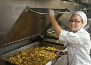 Penn College student Kori A. Treaster, of Lewistown, staffs a kitchen at Churchill Downs as she helps prepare food for guests at the 2016 running of the Kentucky Derby. Treaster and 27 other Penn College students will return for Derby Week in May.