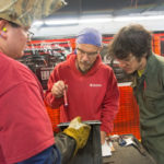 Faculty members (and Penn College grads) Michael K. Patterson, welding lecturer, center, and Benjamin K. Myers, welding instructor, right, judge a competition among students enrolled in Penn College NOW welding courses. While their teachers attended professional development with Penn College faculty liaisons – a requirement to ensure that Penn College courses taught at high schools meet the same rigor as those taught on campus – the students showed their skill in shielded metal arc welding. Following the contest, they took part in a hands-on demonstration by Fronius USA, which has entrusted several pieces of equipment to the college.