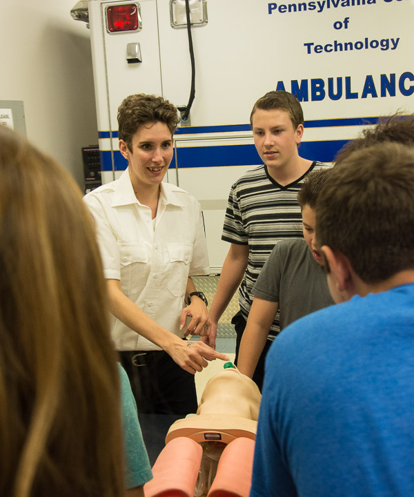 In the paramedic lab, an emergency medical services student demonstrates a nasopharyngeal airway insertion before letting the middle schoolers give it a try.