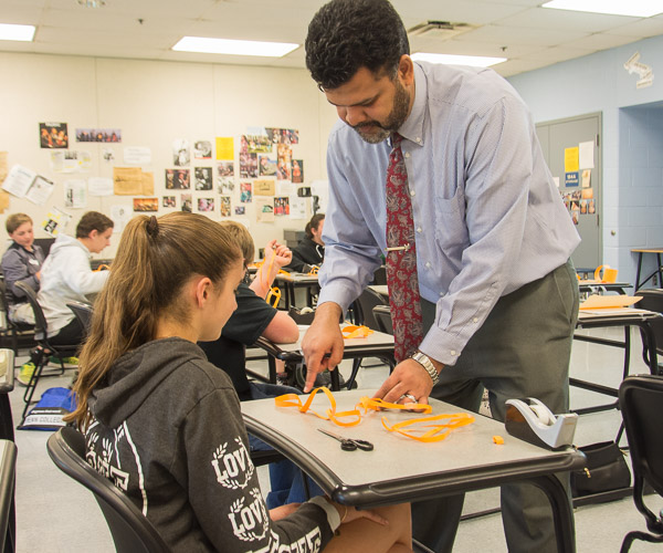 Paul R. Watson, dean of academic services and college transitions, demonstrates the principles of topology as students make and cut Mobius strips.