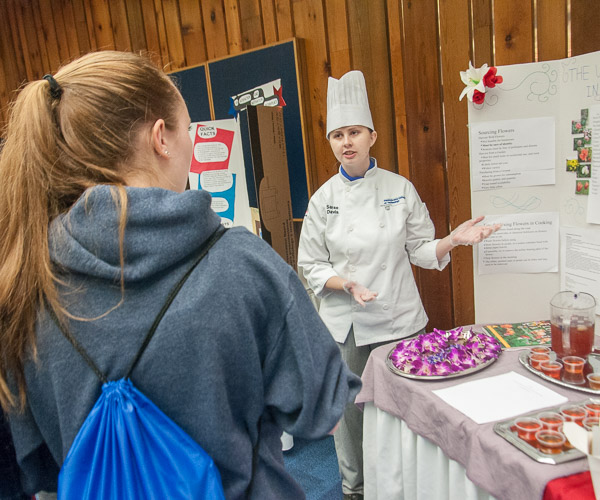 Sarae D. Davis, of Nescopeck, tells visitors from Benton Area High School how flowers can be used in culinary arts.