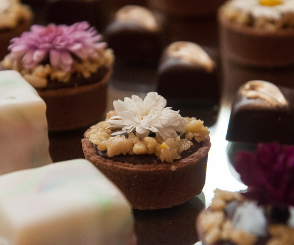 Edible flowers add seasonal flair to Solenberger’s chocolate truffle tarts.