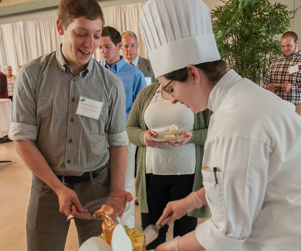 Sonney serves a slice of her “carrot cake garden” to Everett B. Appleby, a student in building science and sustainable design: building construction technology concentration and recipient of the Gerring Geyer Scholarship.