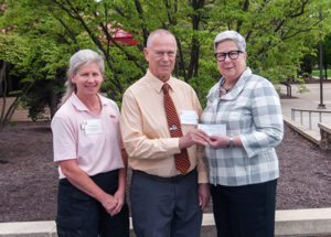 James Yemzow, of the Harrisburg Area Volkswagen Owners Club, accompanied by another HAVOC member, Patricia Shaffer (left) presents a check for the club’s scholarship to Penn College President Davie Jane Gilmour.