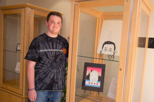 Williamsport Area High School graduate Brayden Cohick with some of his artwork that will be on display in the lobby of The Gallery at Penn College through July 23.