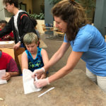 Pawlik shows youngsters that good nutrition can also be fun, with help from student camp assistant Pearl L. Patterson (background).