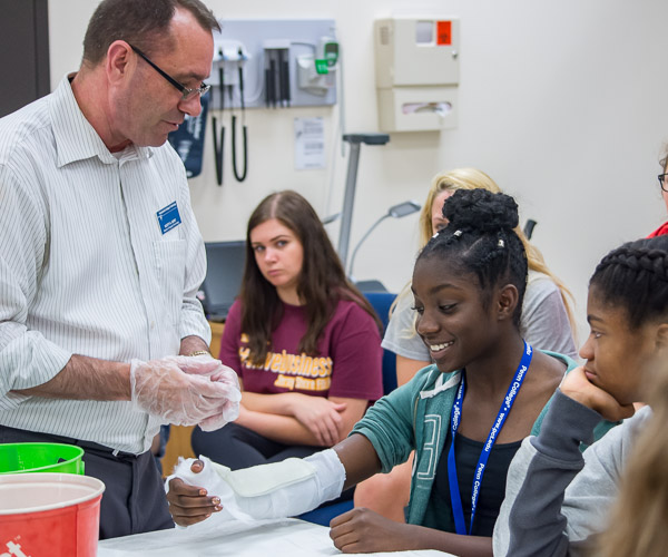 Scott A. Geist, director of surgical technology, delivers a practical lesson to a well-cast volunteer.