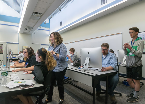 Mallory L. Weymer (standing), coordinator of student health and wellness, and Nicholas L. Stephenson (seated in blue shirt), instructor of graphic design, preside over the Graphic Design Summer Studio.