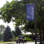 Passing beneath a fitting banner, antique cars enter a campus at which the past is prologue.
