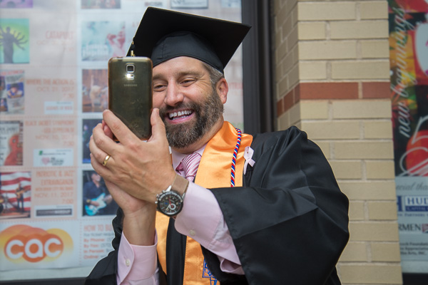Enjoying a lighthearted moment with a college photographer is physician assistant graduate Eric M. Danz, of Hershey. 