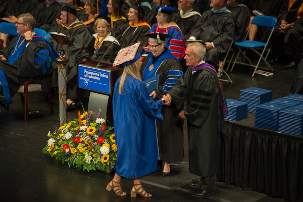 State Rep. Garth Everett, a member of the college’s board of directors, assists in presenting diplomas. 