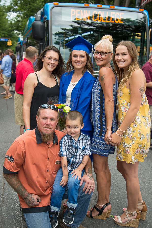 Nicole L. Willets, of Williamsport, an occupational therapy assistant graduate, strikes a pose with her family outside the Arts Center.
