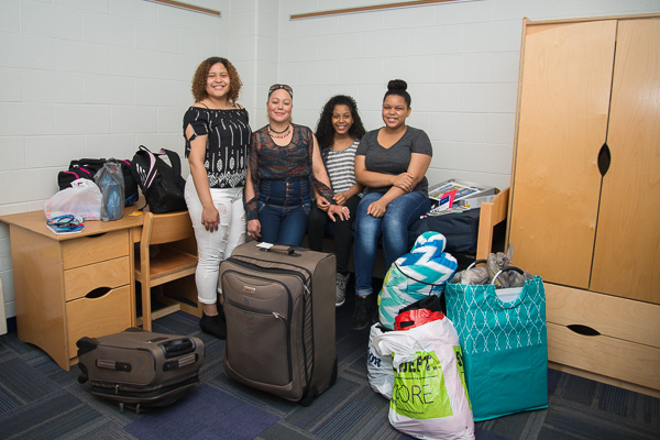 Rossell Burgos, an architectural technology student from Hazleton, settles into her room with the help of her mother and younger sisters.