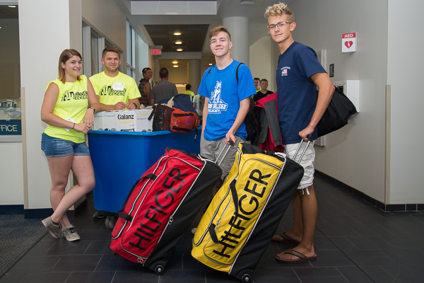 Cody M. Hanson (at center in light blue) receives move-in assistance from a team that includes his younger brother (right). The Reading resident is enrolled in automotive restoration technology. 