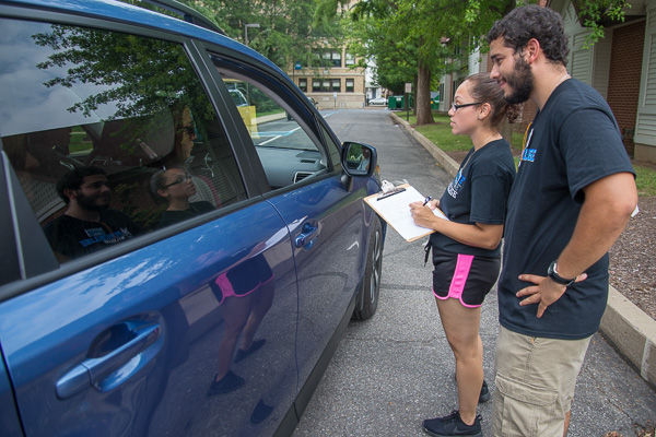 Checking first-year residents into The Village are RAs Glendalis Guadarrama (with clipboard) and Robert Blau. <br />
