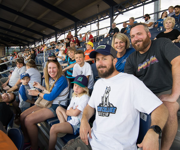 The Hofstroms (front row) and Mackeys, among members of the broader Penn College family, brighten their section.