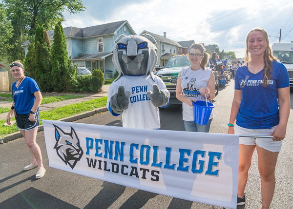 The Cheshire Cat's got nothin' on these grins, happily representing Wildcat Athletics along the parade route.