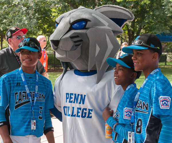 Players from the Caribbean team, traveling here from the Dominican Republic, pose with the Wildcat.